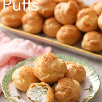 Many cheese puffs on a serving tray with a plate in the foreground.