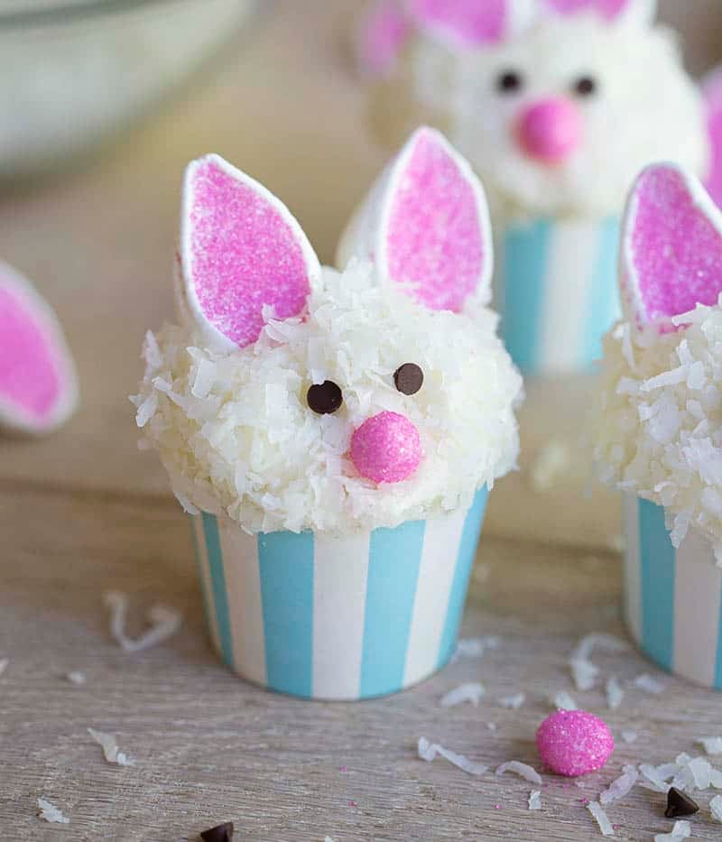 Easter bunny cupcakes on a wooden table.