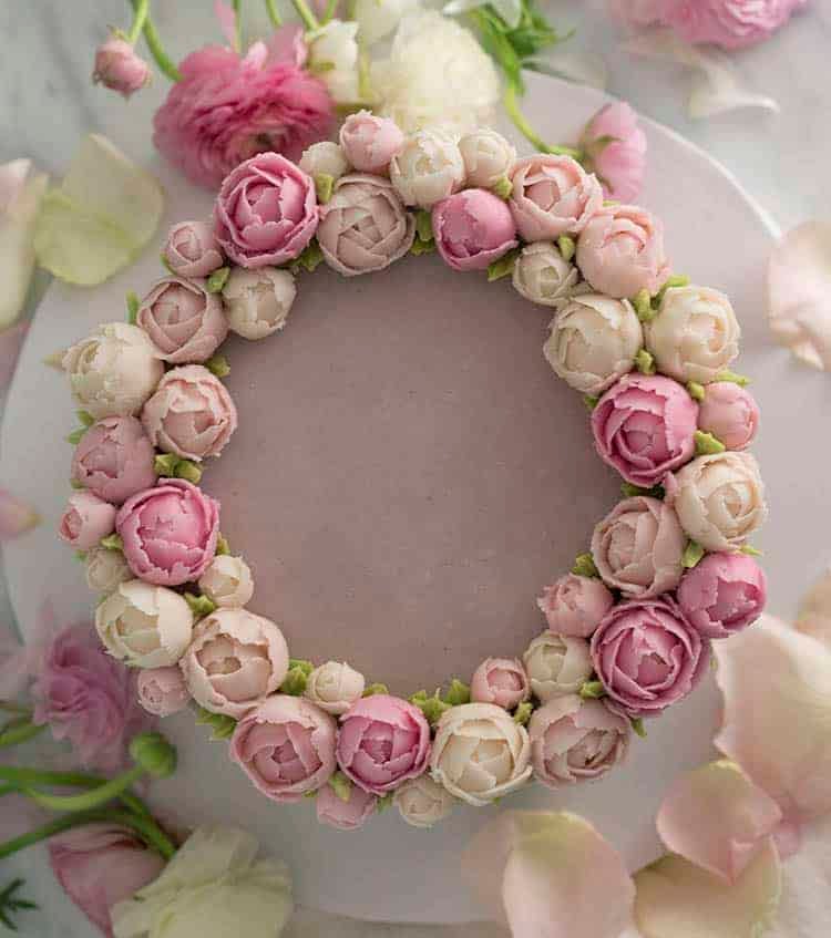 A cake topped with a crown of buttercream peonies.