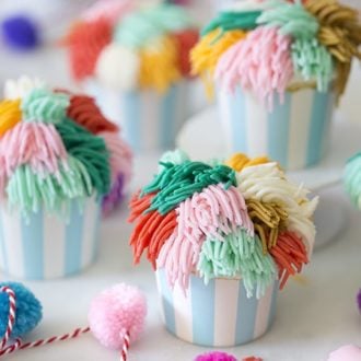 Multiple cute cupcakes with multi-colored frosting.