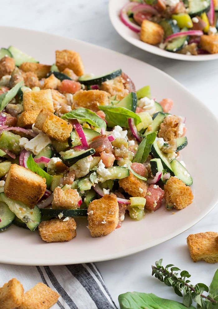 A photo of a panzanella salad on a serving plate.