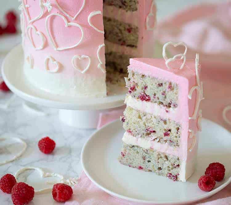 A piece of Valentines raspberry heart cake on a white plate.