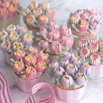 a 3/4 shot of buttercream flowers topping vanilla cupcakes.