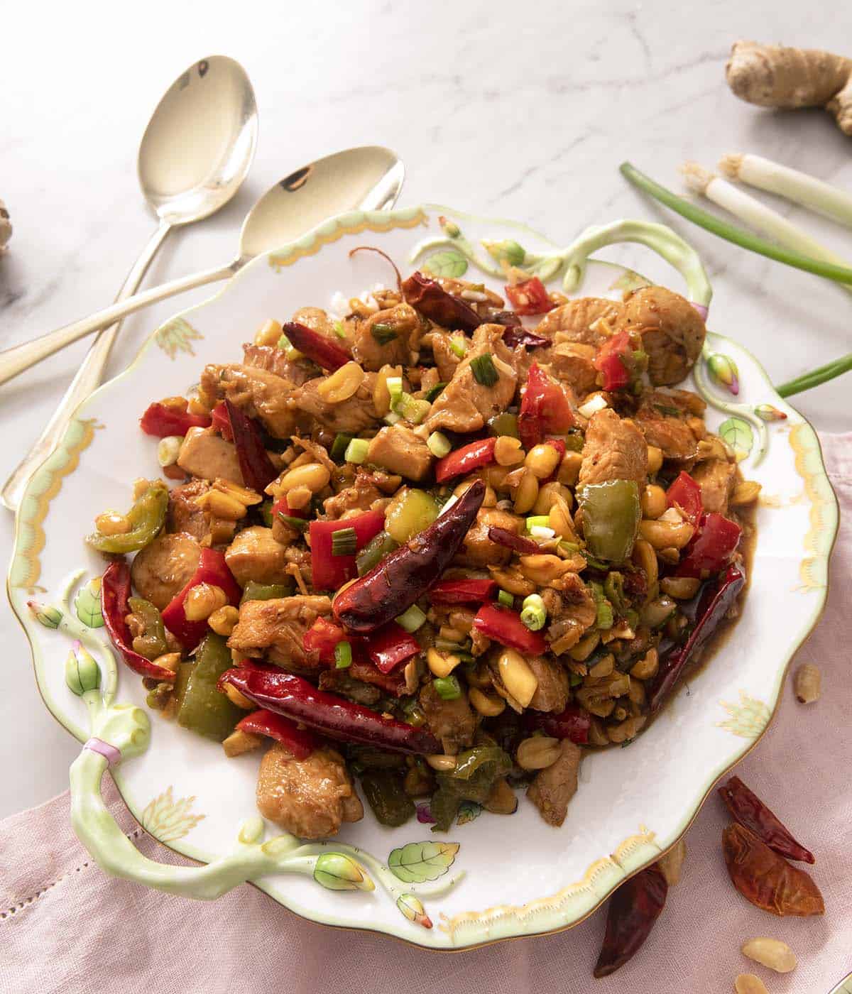 Kung Pao Chicken made from scratch in 20 minutes or less! Stir-fried chicken and vegetables tossed in a sweet, salty and slightly spicy sauce that's hard to resist. You'll never call for take-out again! #kungpao #Chineserecipes Kung Pao chicken on a large serving plate