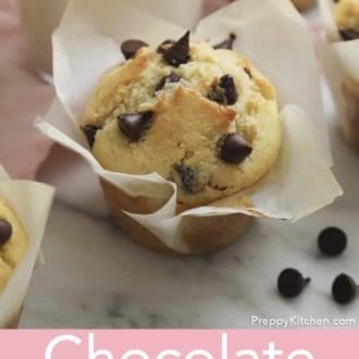 Pinterest graphic showing a chocolate chip muffin on a marble countertop with a glass of milk out of focus behind it.