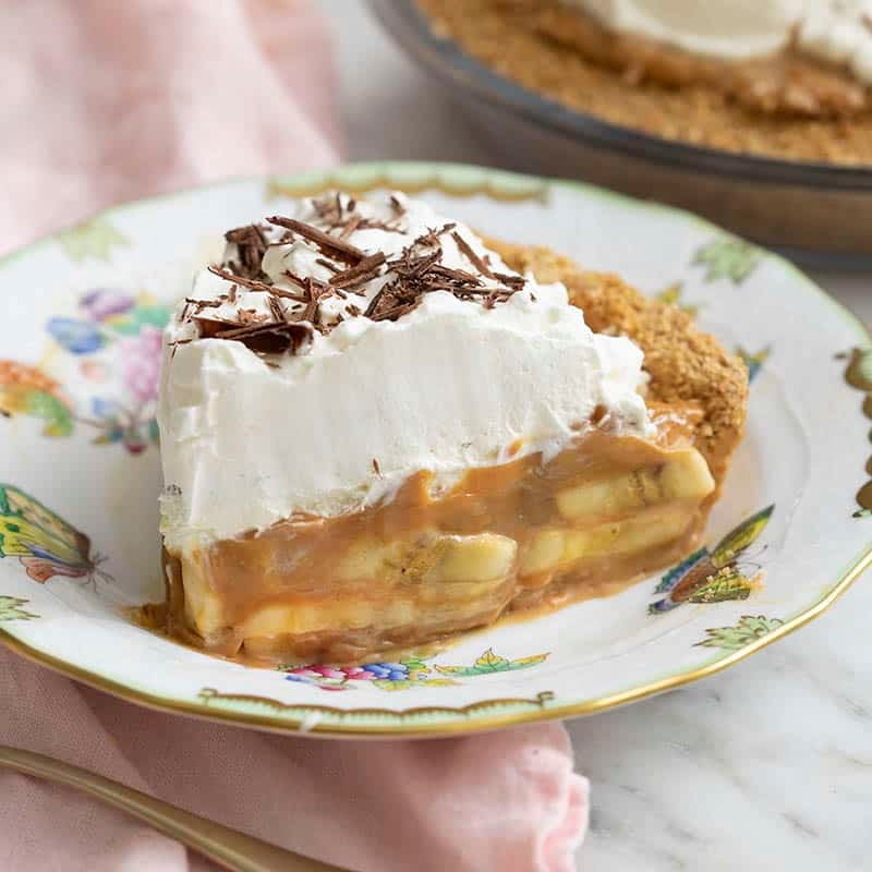 A piece of banoffee pie showing the bananas and dulce de leche inside.
