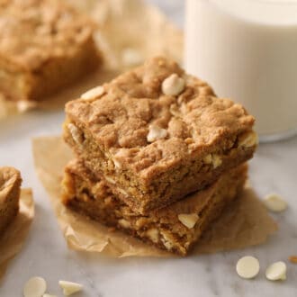 Pinterest graphic of a blondies with white chocolate chips on a marble table.