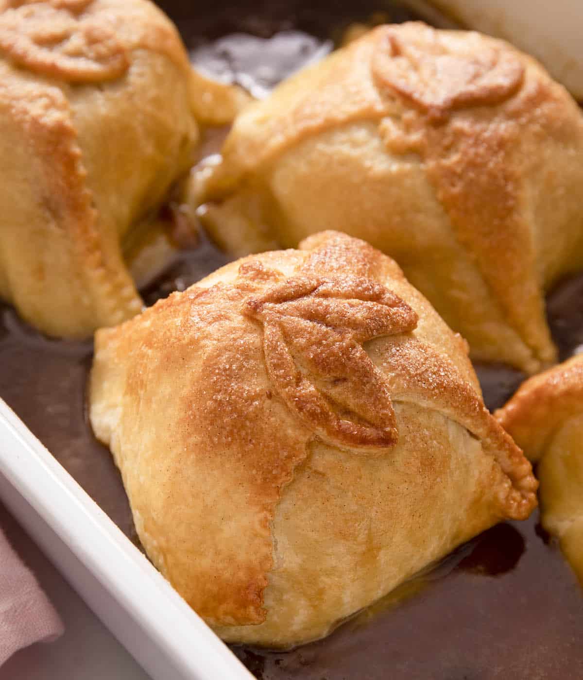Golden apple dumplings in a baking dish.