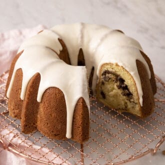 A sock it to me cake on a copper cooling rack.