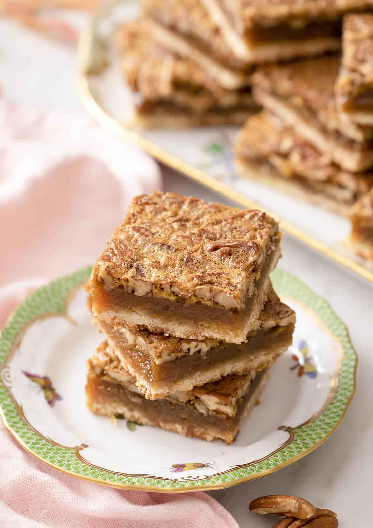 Three pecan pie bars on a small plate.
