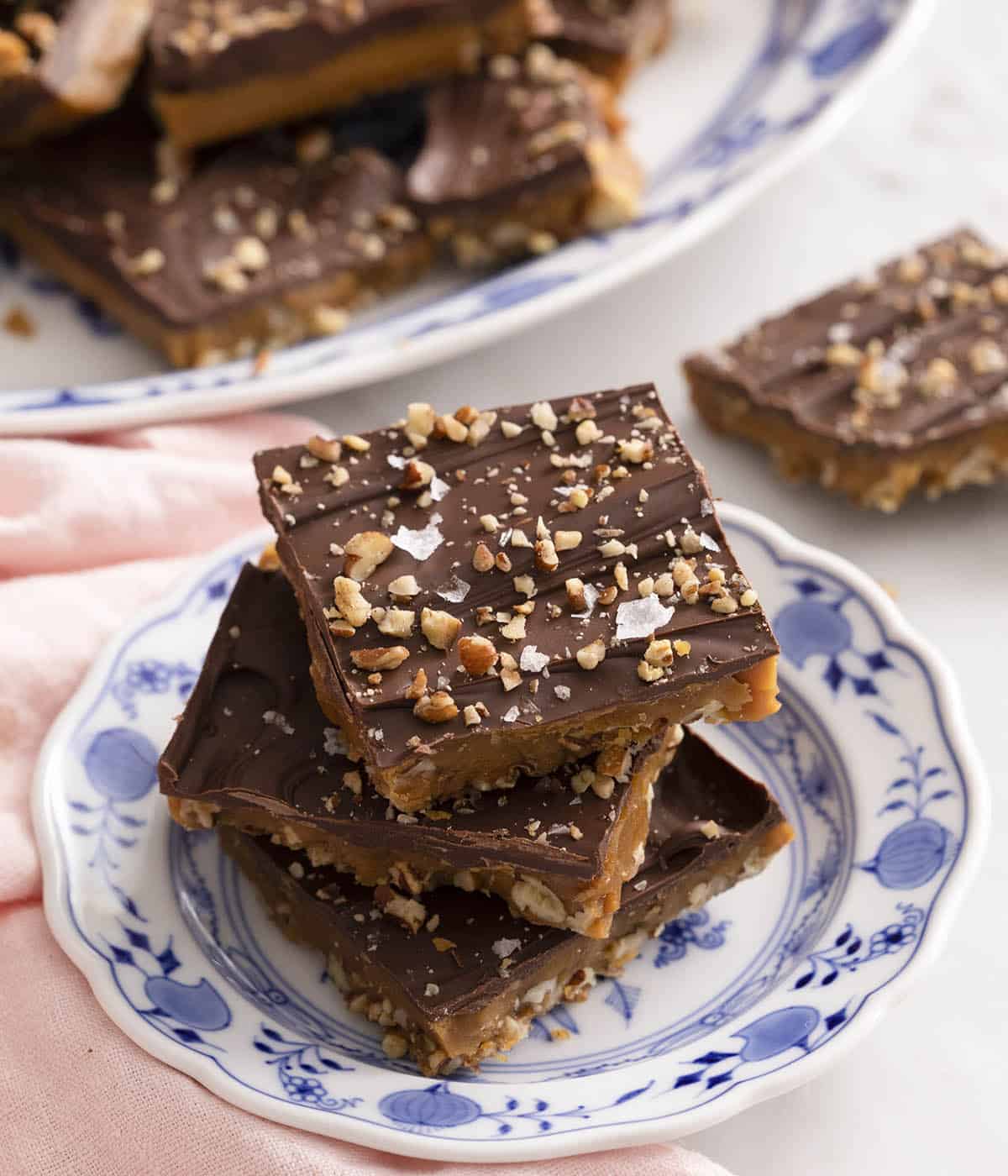 Three pieces of toffee on a small blue and white plate.