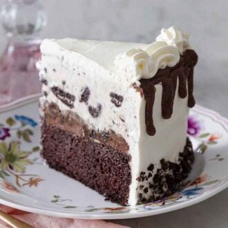 A slice of ice cream cake with Oreos on a floral plate.