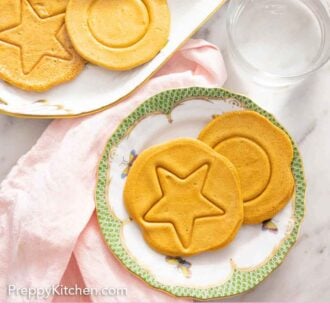 Pinterest graphic of the overhead view of two dalgona candies on a plate beside a platter.