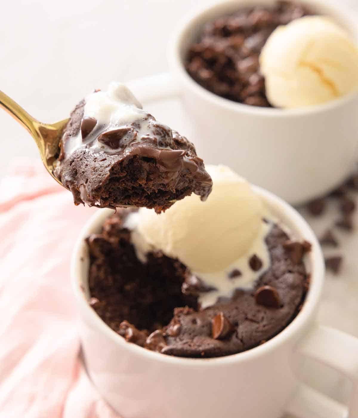 A spoonful of brownie lifted from the mug.