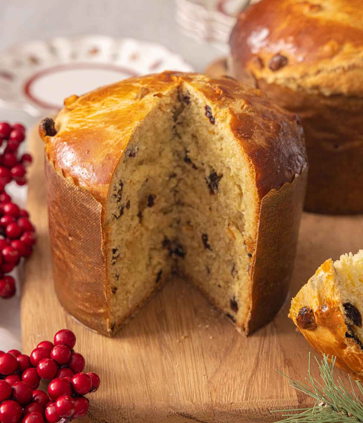 A cutting board with a loaf of panettone with a slice cut, showing the interior.
