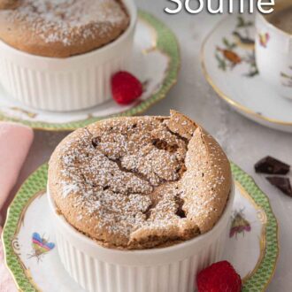 Pinterest graphic of a chocolate souffle with powdered sugar on top with a raspberry on the side.
