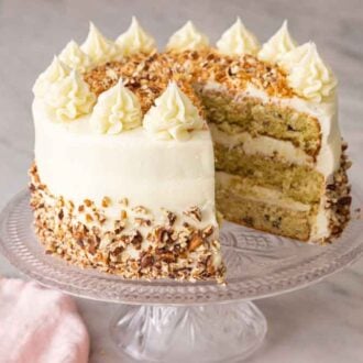 A cake stand with an Italian cream cake with a slice cut out.