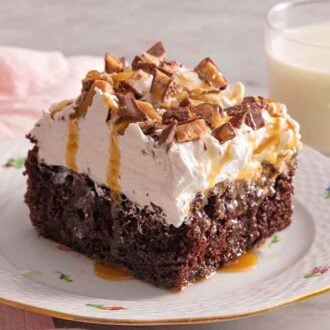 A plate with a square slice of better than sex cake with caramel dripping down.