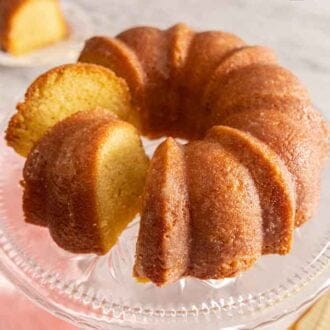 A cake stand with a butter cake with slices cut, not yet served.