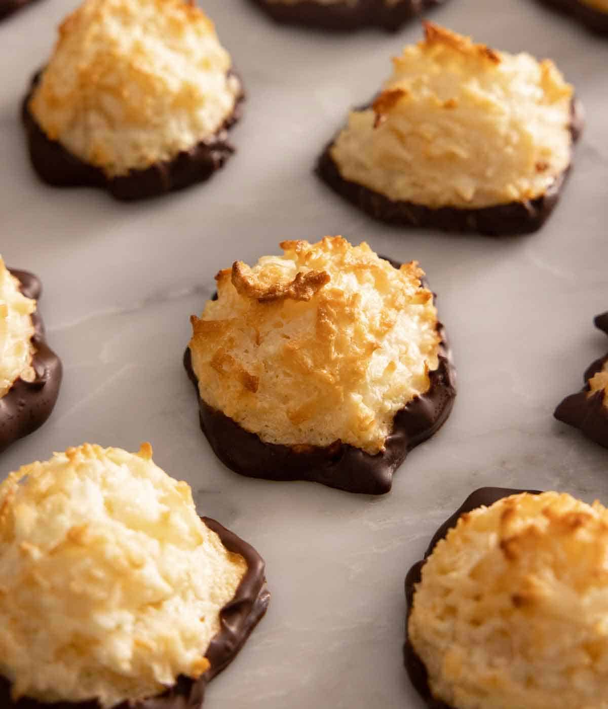 A few coconut macaroons in a single layer on a marble surface.