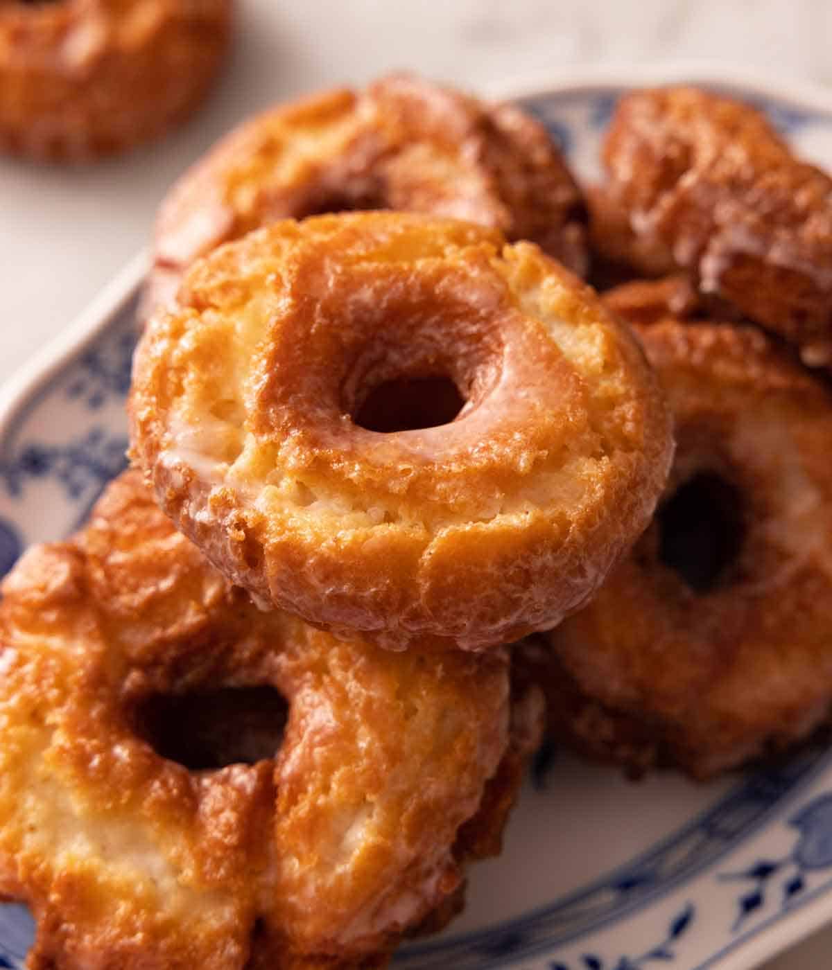 A platter with multiple old fashioned donuts in a pile.
