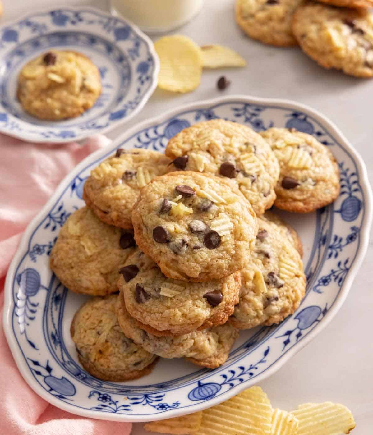 A platter of potato chip cookies with chips scattered around.