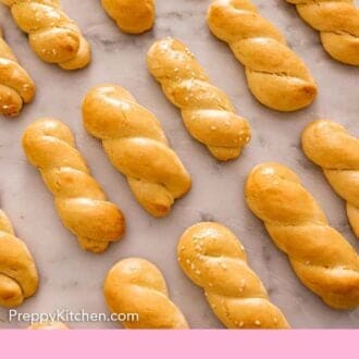 Pinterest graphic of koulourakia lying flat in a single layer.