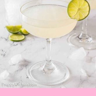 Pinterest graphic of a glass of gimlet with a slice of lime on the rim with another drink, container of ice, and limes behind it.