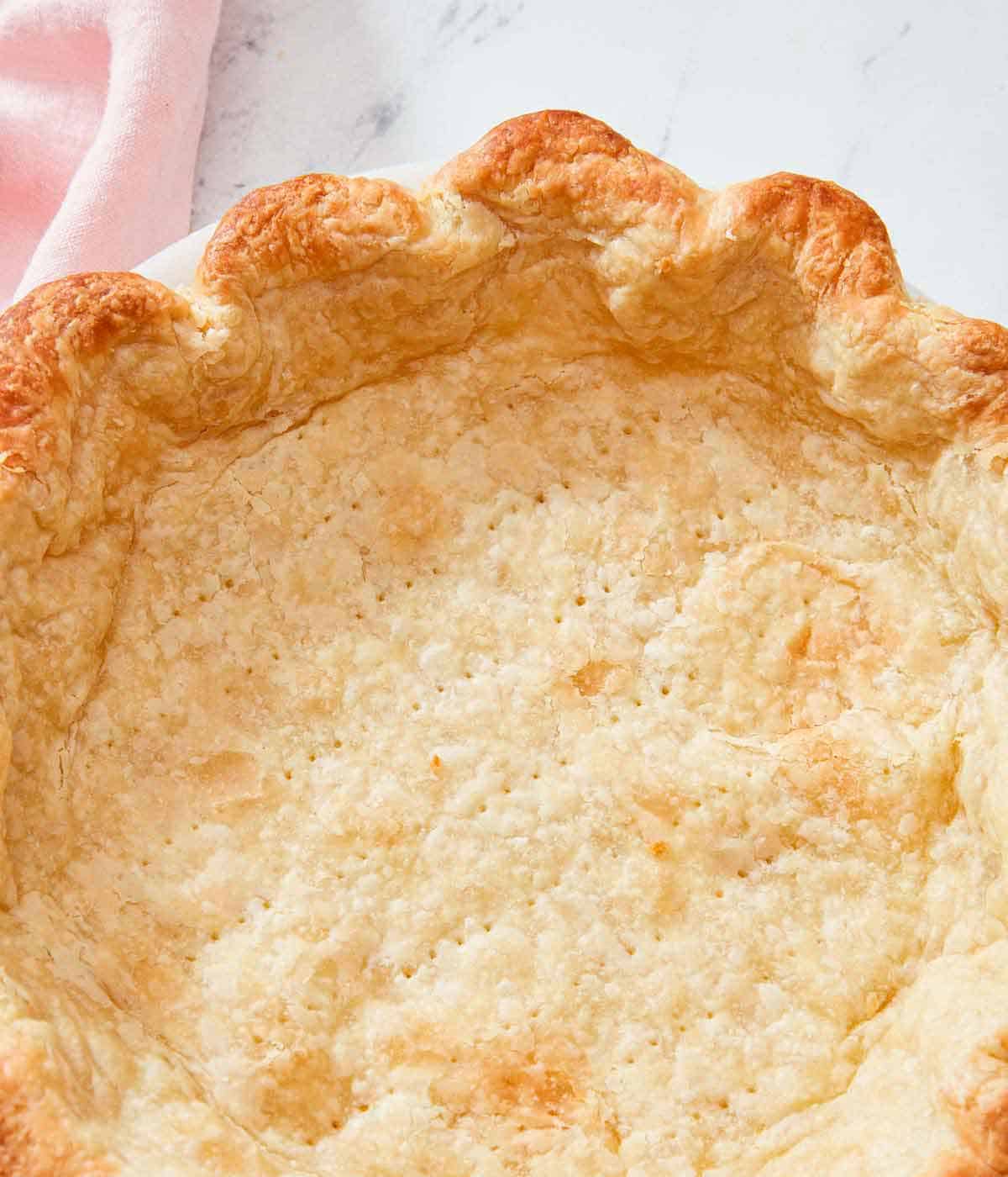 Close up of a golden blind baked pie crust.