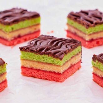 Multiple pieces of rainbow cookies on a white surface.