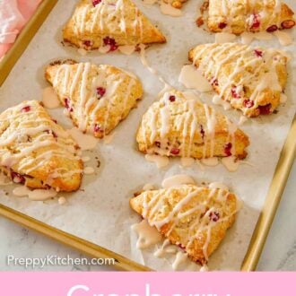 Pinterest graphic of a sheet pan with multiple cranberry orange scones with glaze drizzled on top.