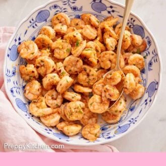 Pinterest graphic of an overhead view of a large plate of sautéed shrimp with a spoon tucked inside.