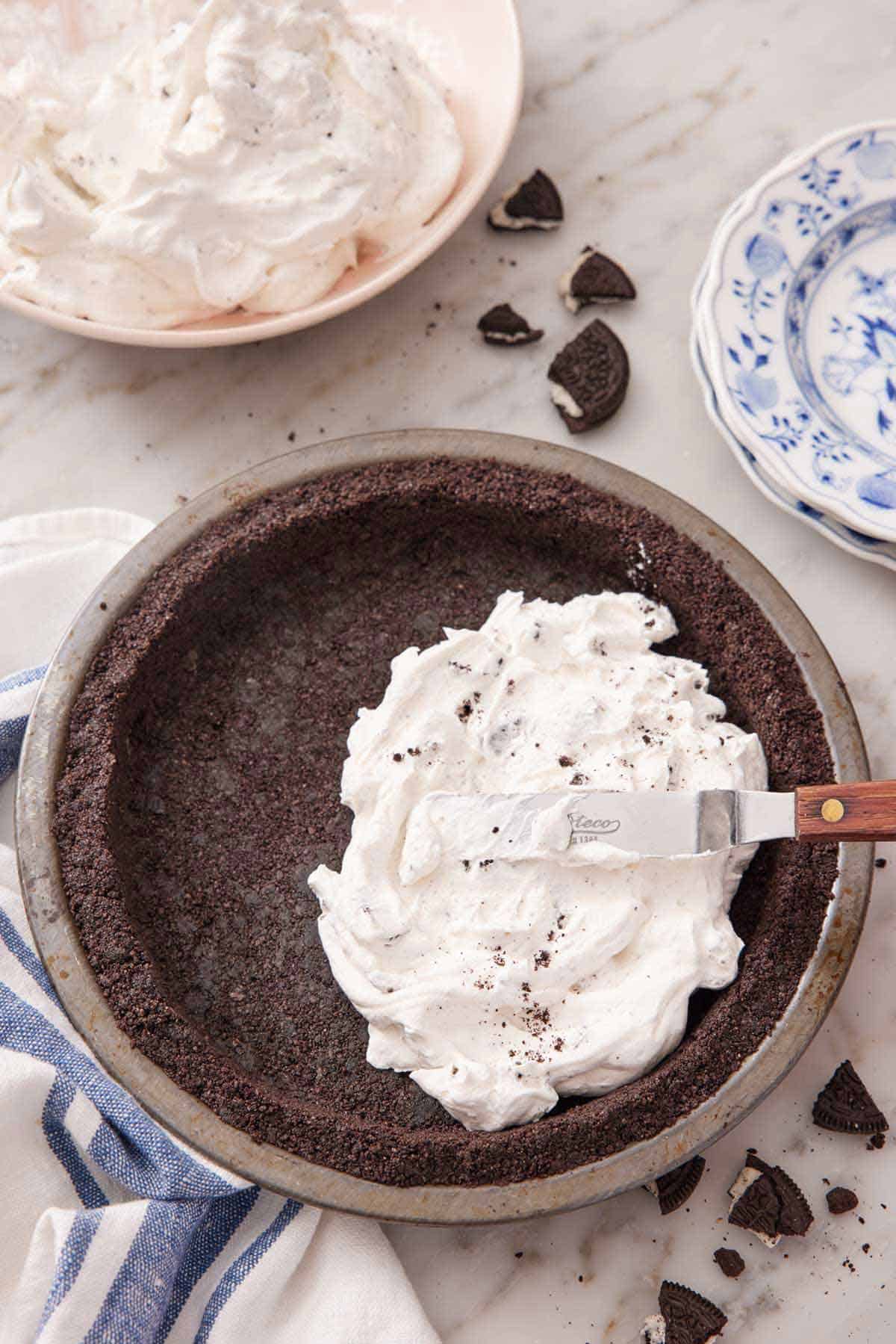 Overhead view of filling being spread into an Oreo pie crust.