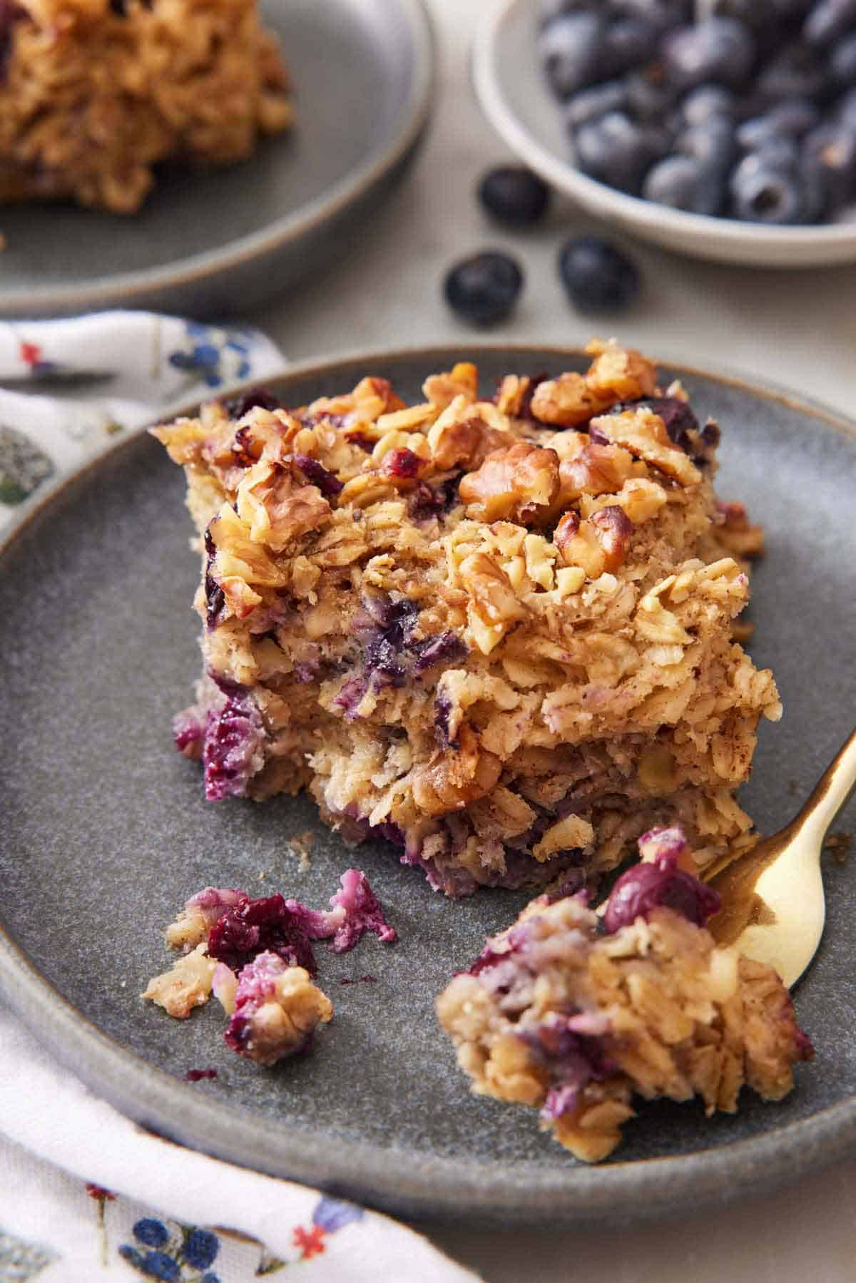 A plate with a square piece of baked oatmeal with a corner scooped off onto a fork.