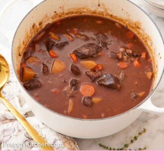 Pinterest graphic of a white dutch oven with beef stew inside. Some bowls, bread, and a ladle around the pot.