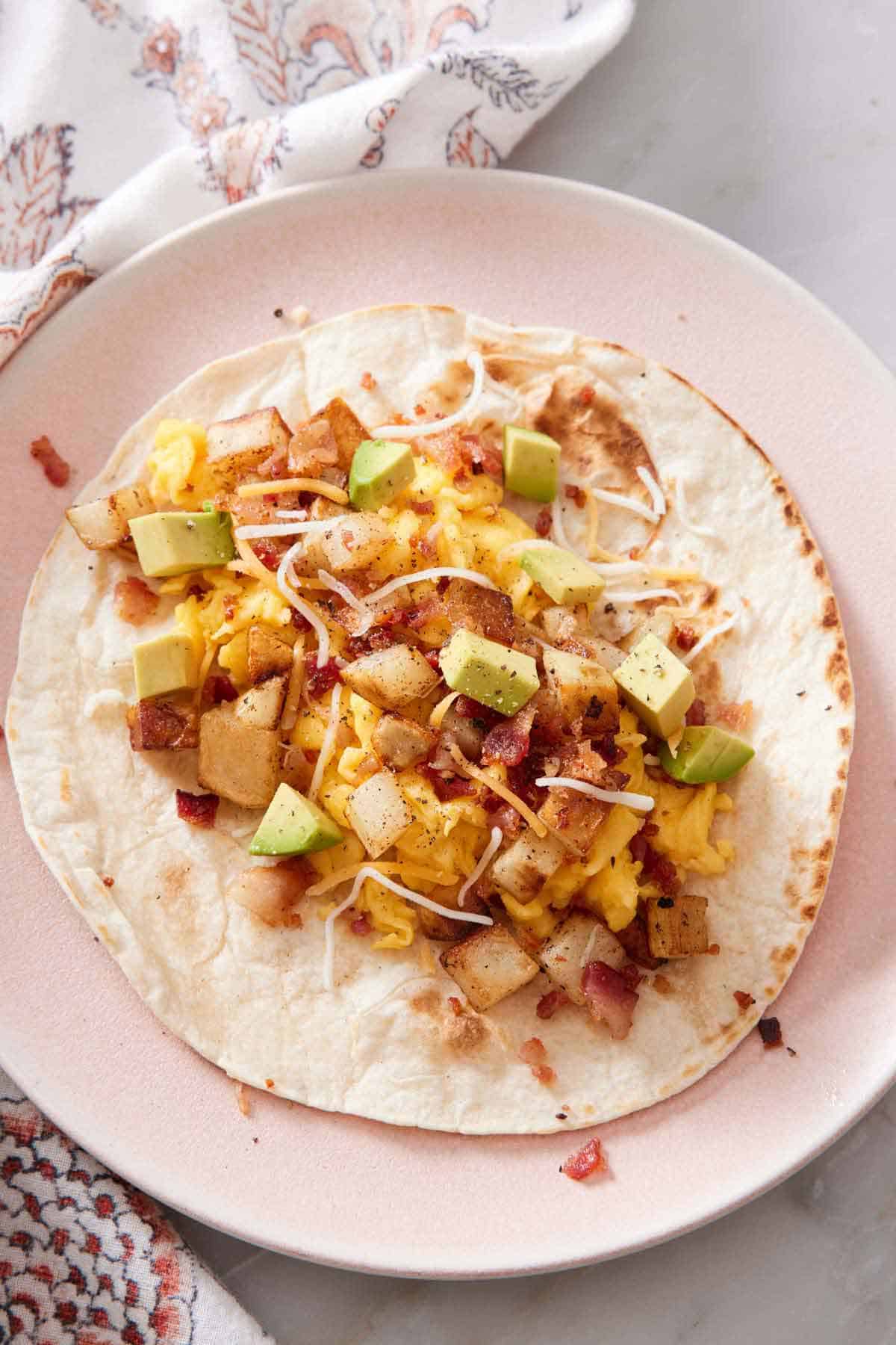 Overhead view of an opened breakfast taco on a plate.
