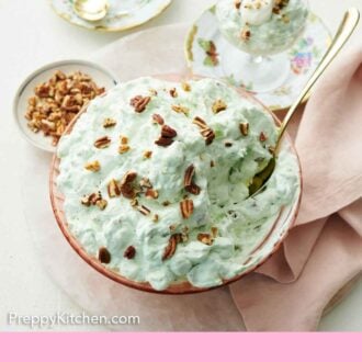 Pinterest graphic of a serving bowl of Watergate salad topped with chopped pecans. Two plated servings on the side.