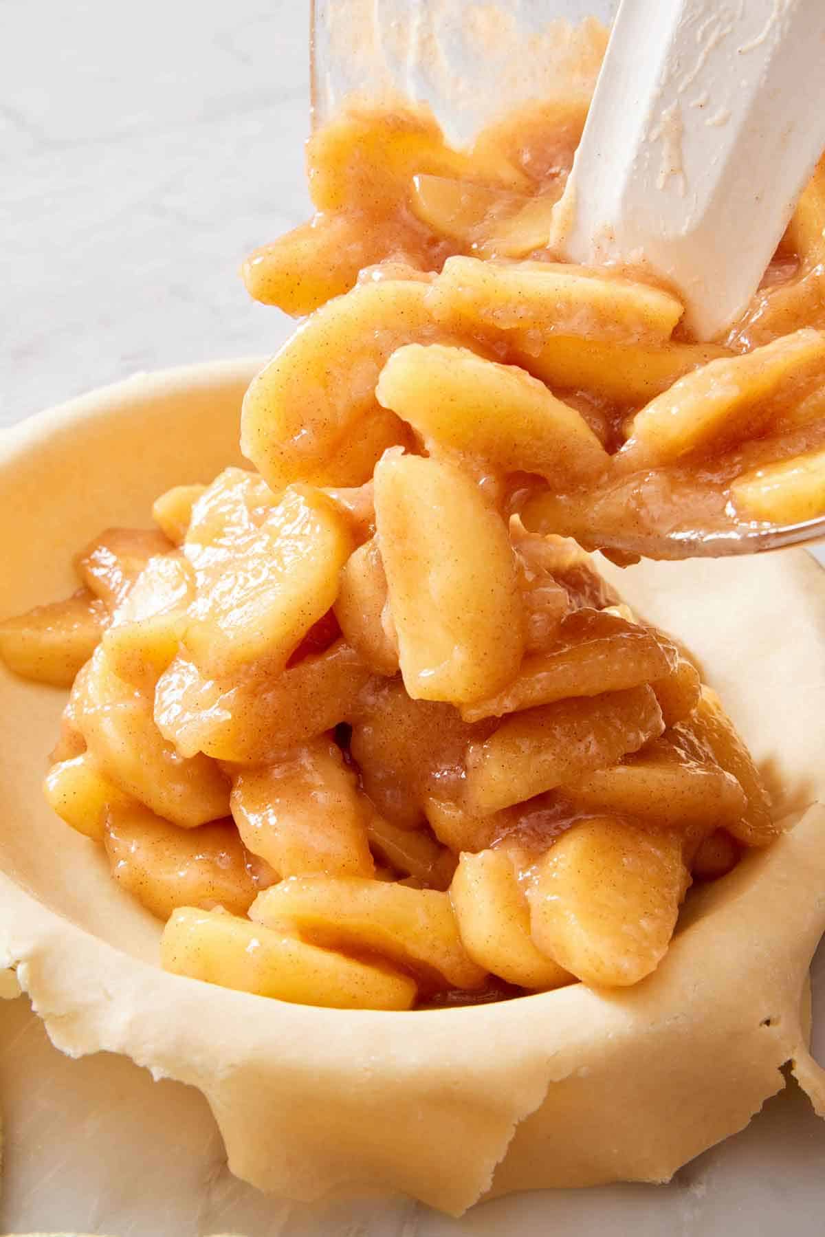 Apple pie filling poured into a pie crust.