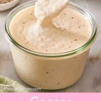 Pin image showing a spoon dipped into a jar of Caesar salad dressing.