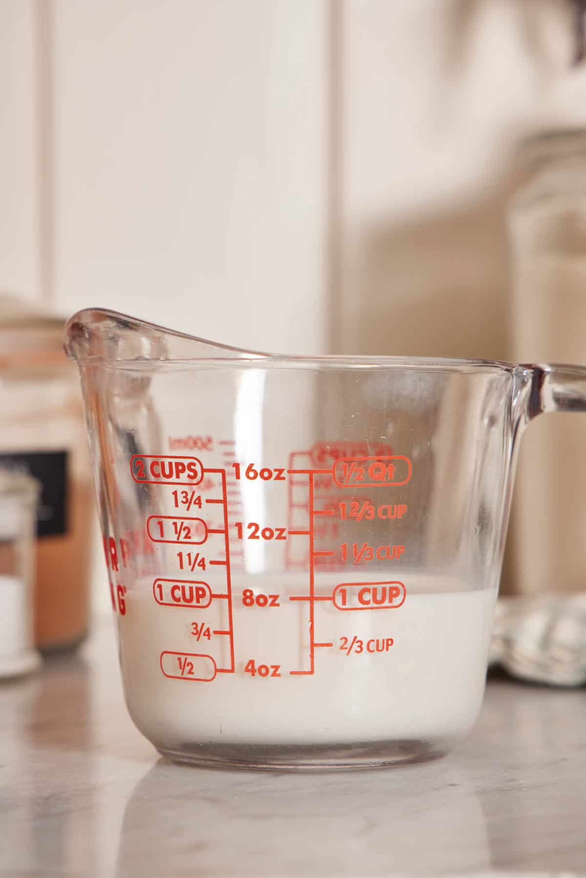 Close-up of a measuring jug with milk.