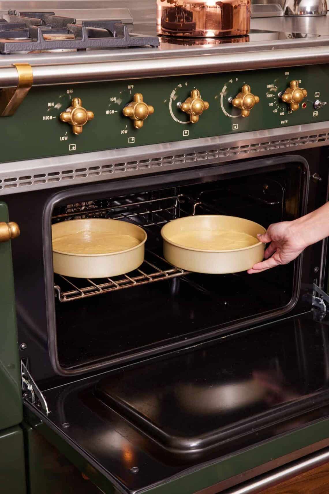 Two cake pans placed in an oven.