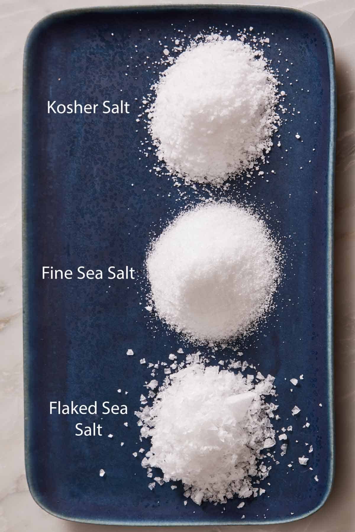 Overhead shot of a blue platter with three piles of different salts.