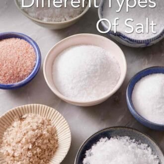 Pinterest graphic showing different types of salt in bowls on a marble counter.